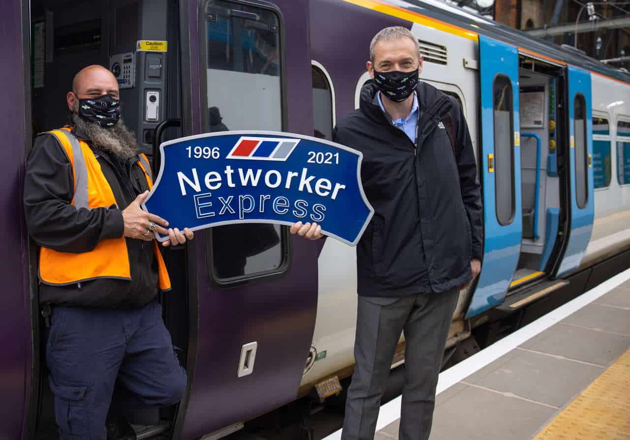 Driver Paul French (left) and Route Operations Assurance Manager Steve Castle proudly hold the headboard ahead of the last Class 365 out of King's Cross