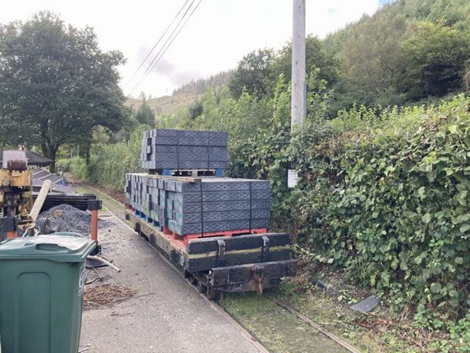 Sleepers are loaded and awaiting a locomotive to bring them down-to outside-the engine shed.