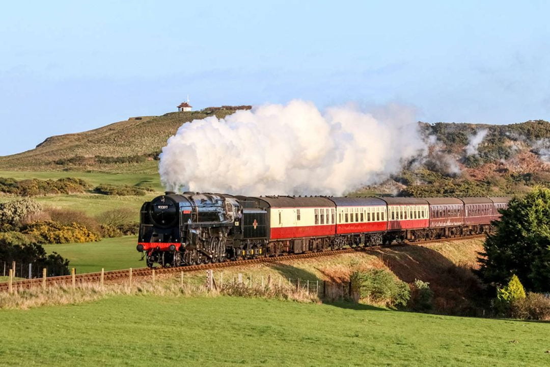 The North Norfolk Railway’s flagship locomotive No 92203 “Black Prince” at the head of a heavy train from Sheringham to Holt