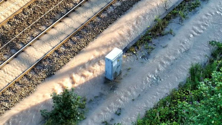 Railway equipment in flowing floodwater after burst water main