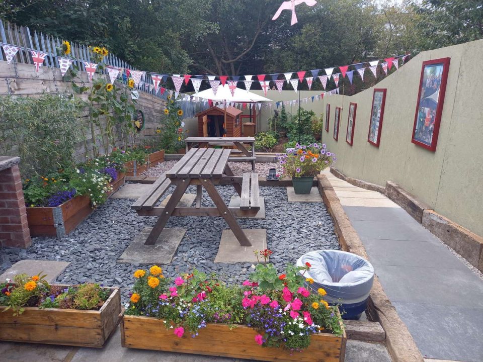 Barrow memorial garden with planters, a picnic bench and colourful flowers