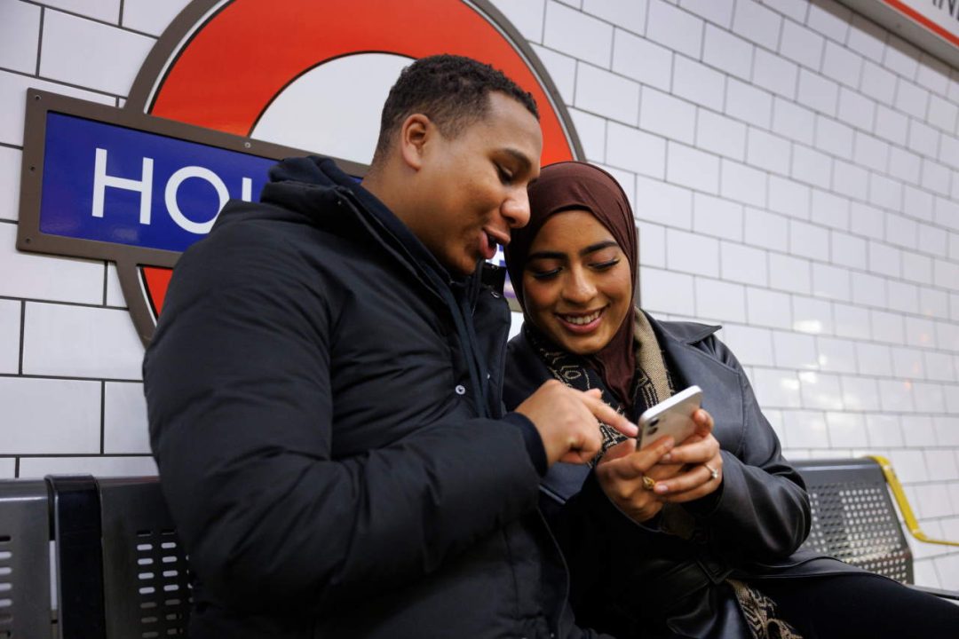 Passengers using mobile on Holland Park platform