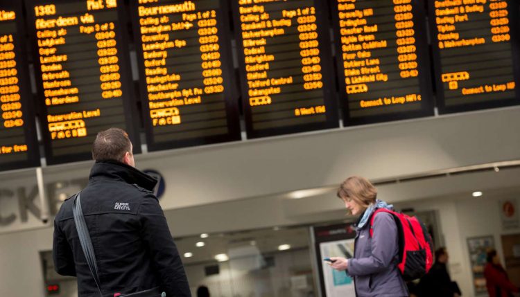 Passengers in front of departure board 