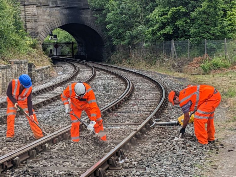 Ballast being shovelled into place around new sleepers at East Lancashire Railway