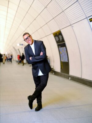 Gok Wan. Posing on an underground station platform'