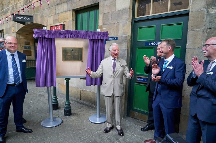 King Charles III unveils a plaque at Pickering Station to mark the occasion of his visit