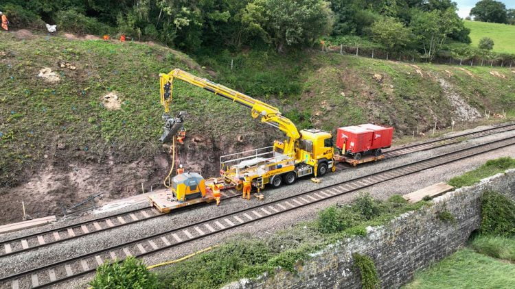 Drone shot of rope worker and rock bolt being drilled