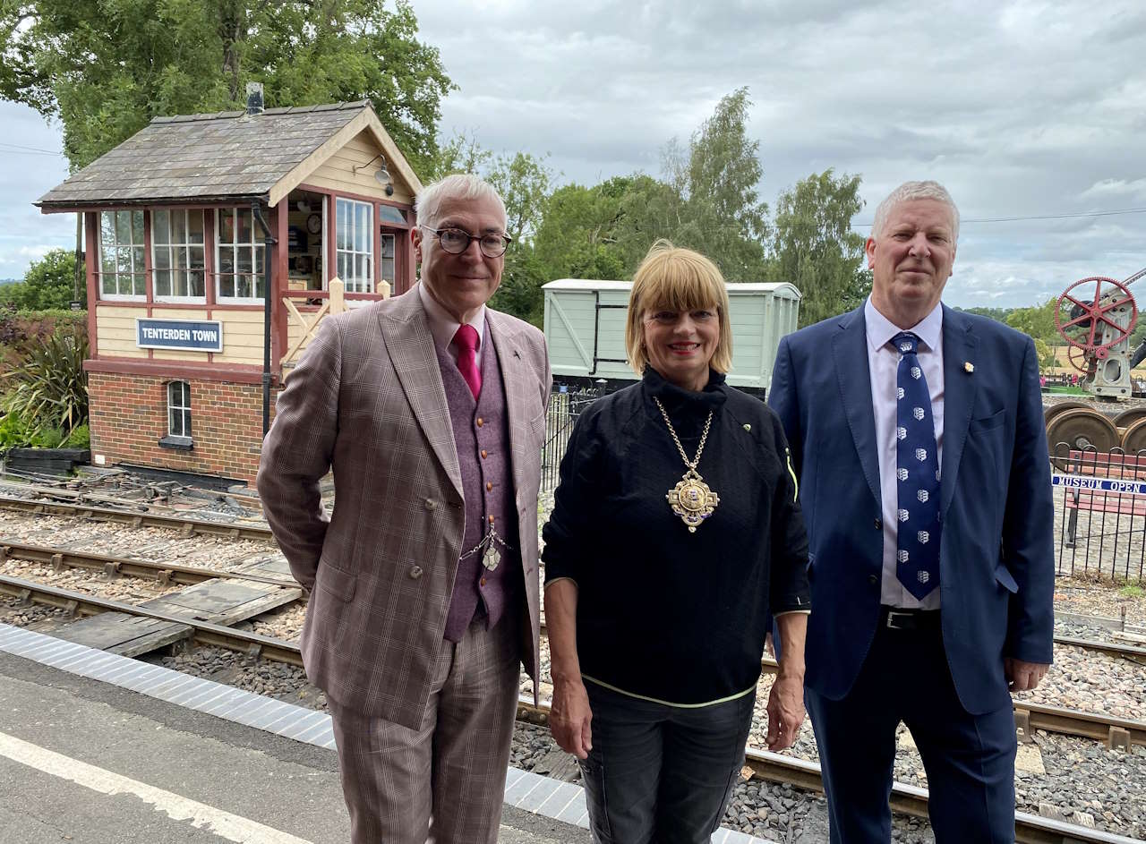 (Left to right) K&ESR General Manager Robin Coombes; Mayor of Tenterden Cllr Sue Ferguson and Coronation-appointed Baron of the Cinque Ports, Tenterden, John Crawford, standing on the town station platform with the former Chilham signal box visible behind them.