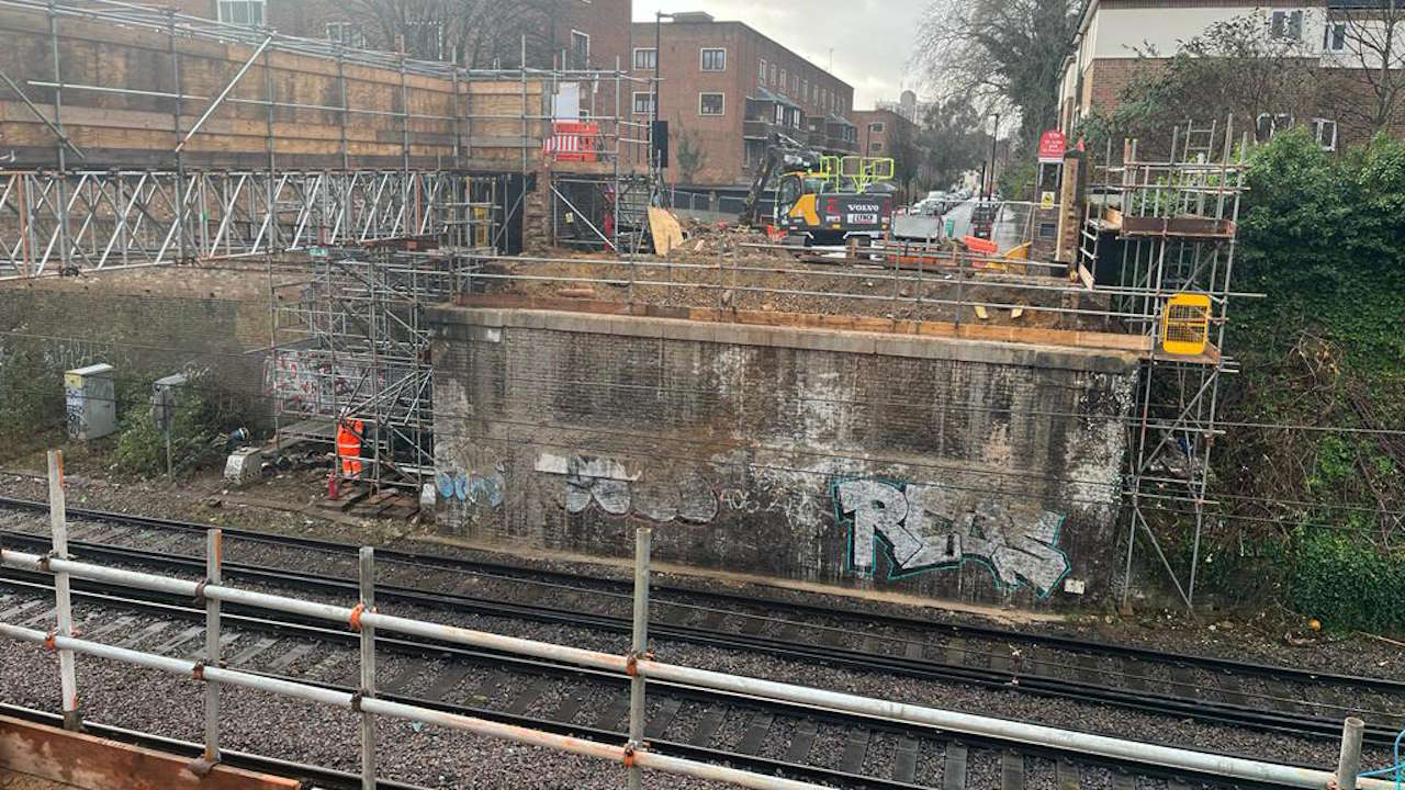 Engineers preparing to lift in the new bridge across the railway. The temporary structure carrying electricity connections can be seen to the left