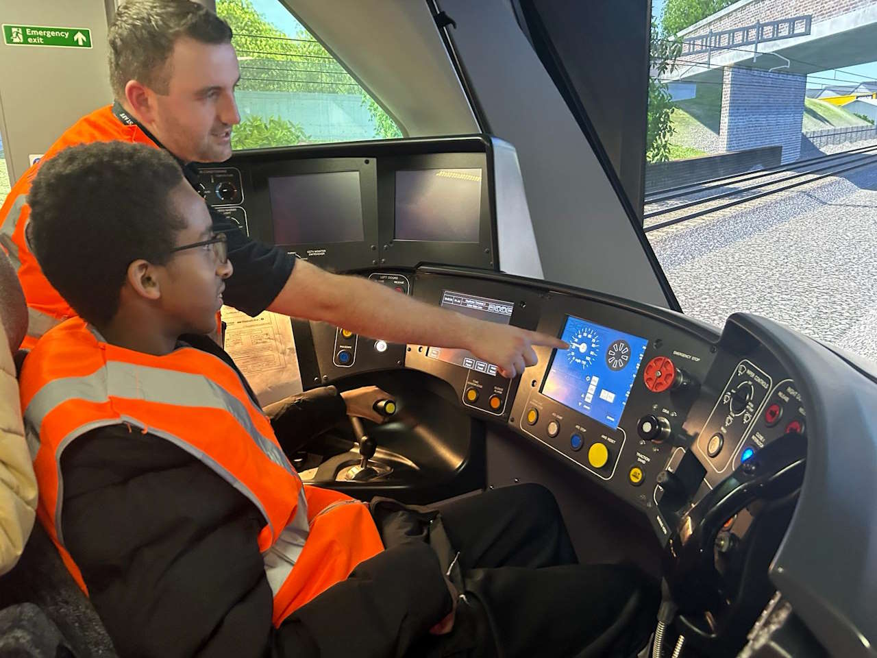 James Harrison, Senior Depot Manager at Alstom with a pupil from Ealing SEND Hub utilising the train simulator at Alstom’s Old Oak Common depot