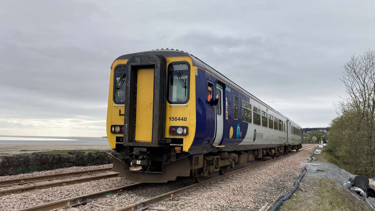 A Northern train travelling through Grange-over-Sands