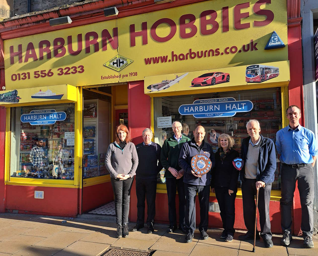 Pictured (L-R) are Harburn Hobbies staff Ann, George, and Ronnie, Ron Jones (Bachmann Europe), Gill & Bob Baird (owners) and Grahame from Harburn Hobbies. // Credit: Bachmann Europe