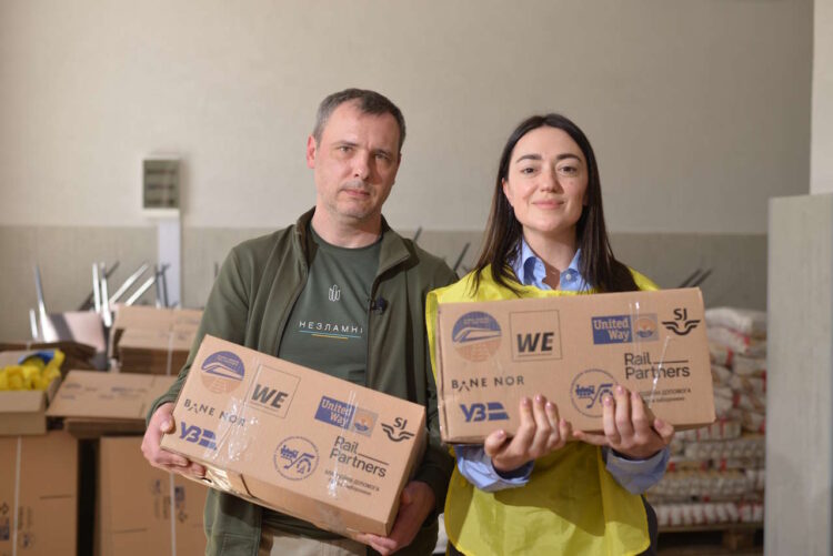 WE Aid workers with 
donated parcels. // Credit: Rail Partners.