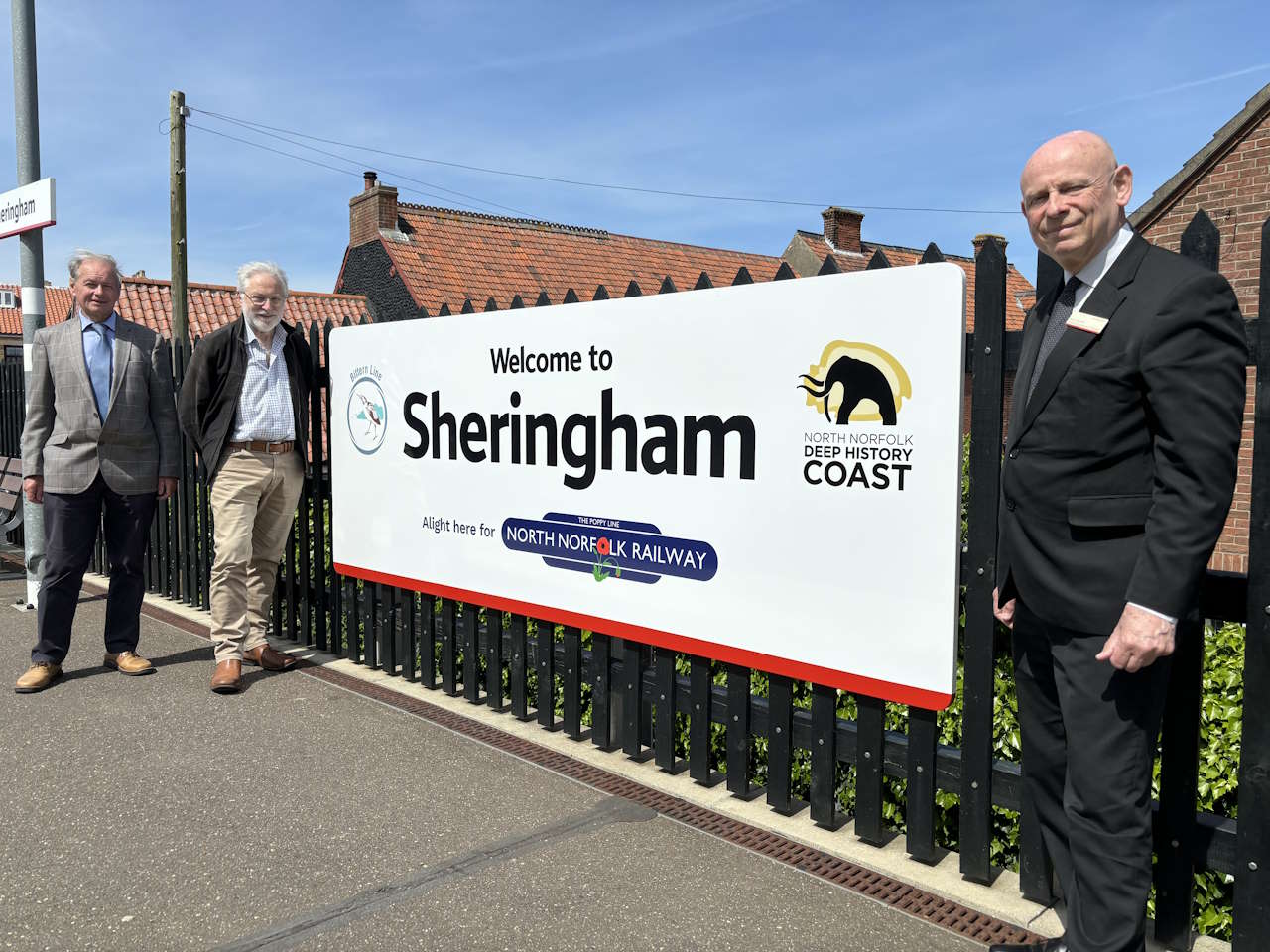 Sheringham station welcome sign From left Chris Mitchell and David Pearce from Bittern Line CRP and Alan Neville from Greater Anglia. Credit: Bittern Line CRP