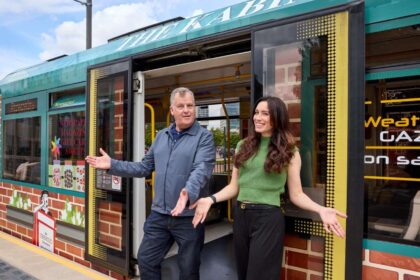 Corrie actors Julia Goulding and Peter Gunn pose with the Coronation Street Experience-themed tram.