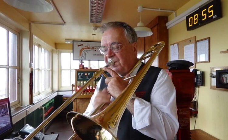 Ted Beausire playing his trombone in Porthmadog Harbour signal box. Credit: Ffestiniog and Welsh Railways