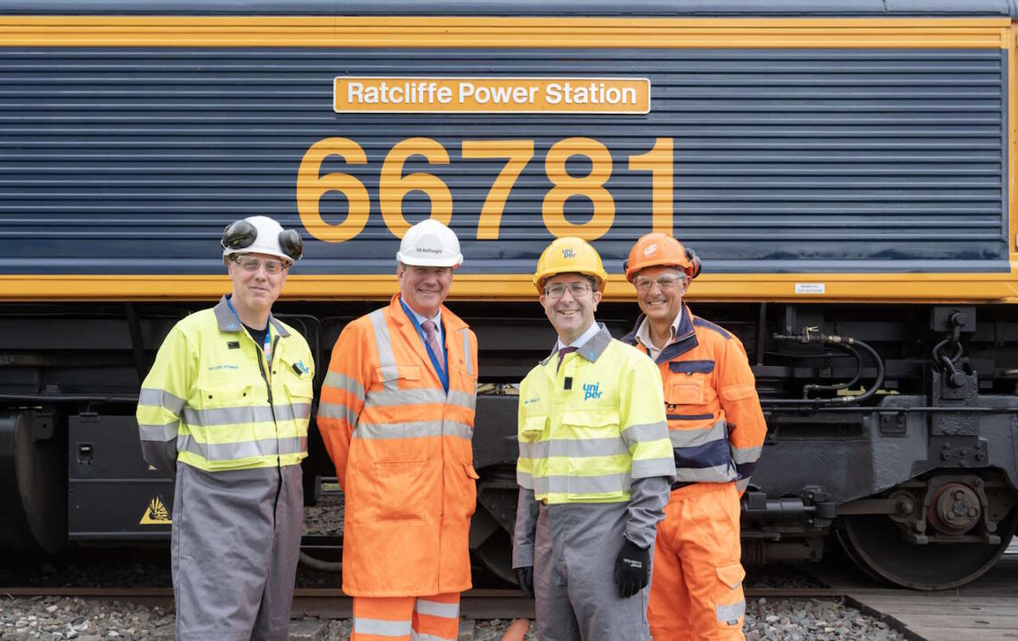 4 people stand in front of newly named locomotive