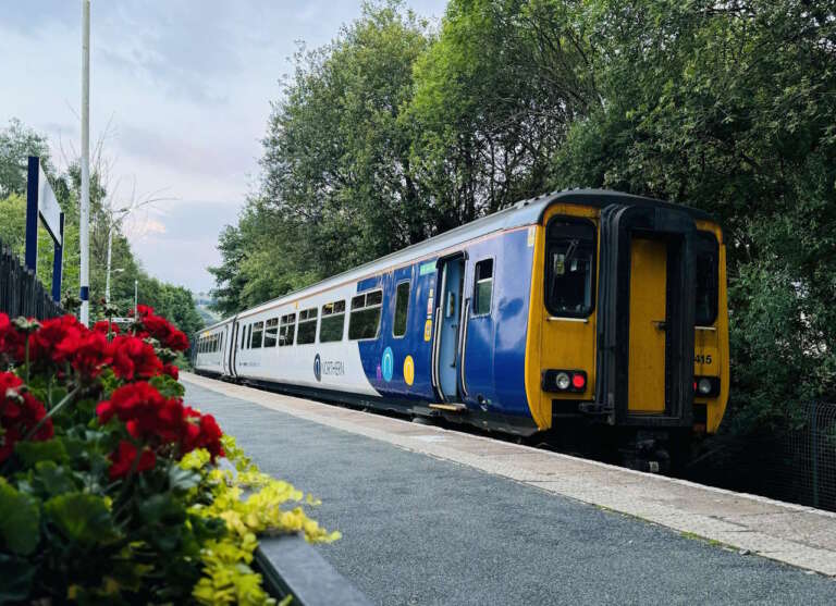 Northern's 156415 stands at Colne with a Preston service