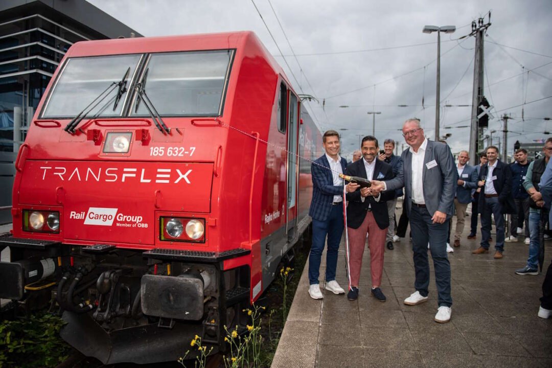 People stand in front of locomotive