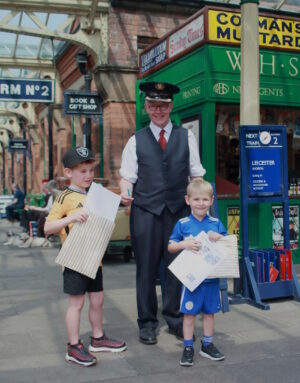 Two Children stand with a Great Central Railway Volunteer