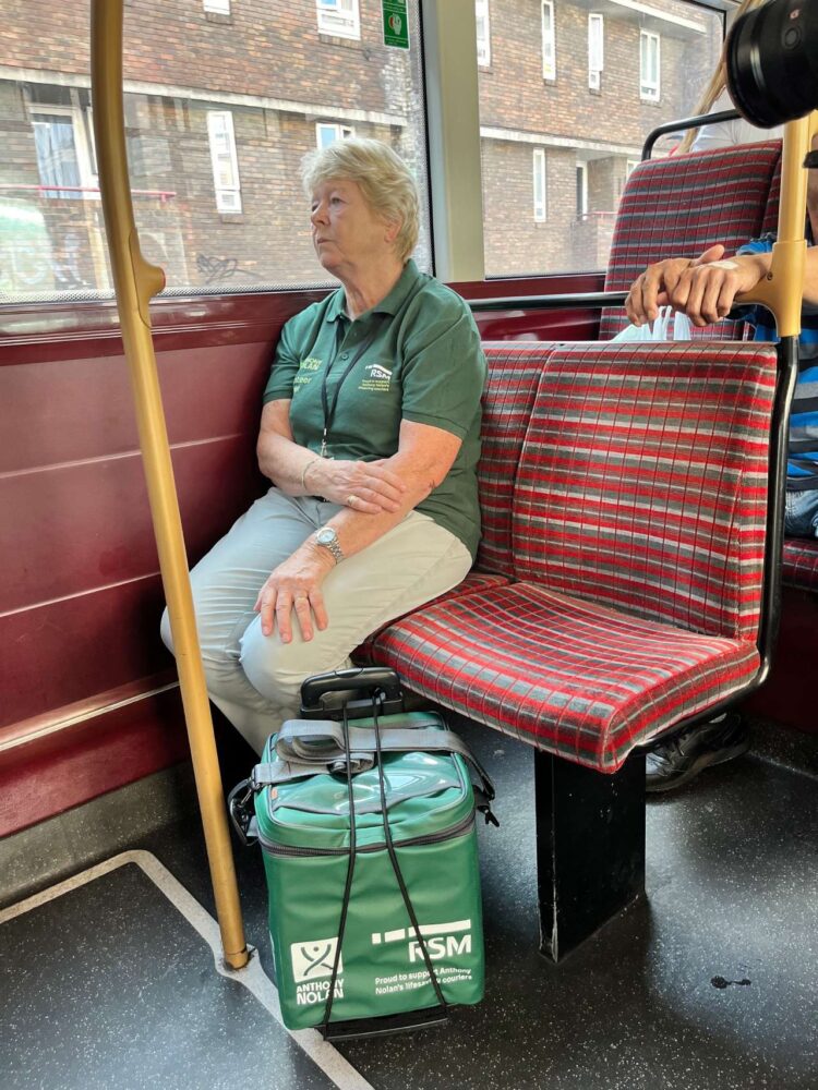 Volunteer courier Irene travelling by bus