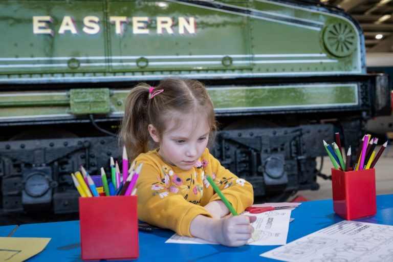 A young girl designing her entry for the competition - London North Eastern Railway