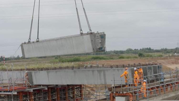 Close-up of a concrete beam being placed in place