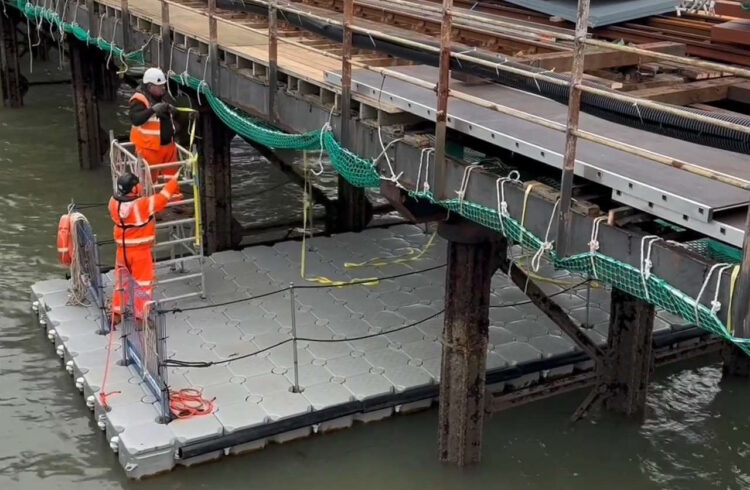 Engineers working from a pontoon on Ryde Pier. // Credit: Network Rail