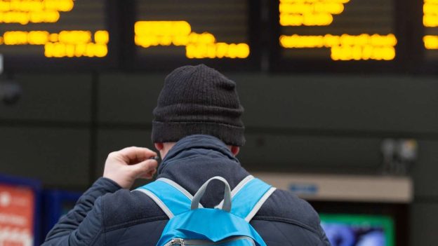 Customer at departure screens. // Credit: Northern