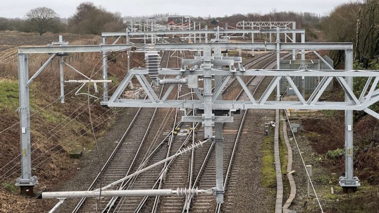 New overhead line stanchions and cables between Wigan to Bolton. // Credit: Network Rail